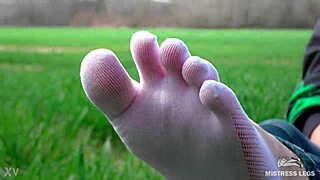 goddess feet in cute white socks on spring grass field
