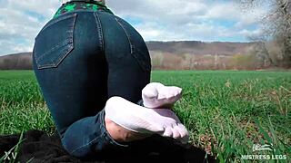 Goddess Feet In Cute White Socks With Jeans On The Spring Grass Field