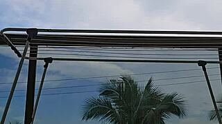 Naughty employee flashes big ass under skirt on balcony