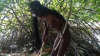 Naked skinny tribe woman prepares bow for hunting