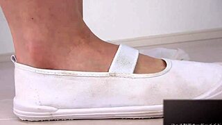 A woman applies lotion to her soles, moaning erotically