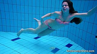 Hey, this cute young woman reveals her stunning smooth body while swimming underwater at the beach pool