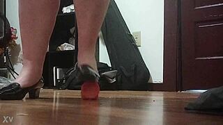 Woman crushes cock under sharp heels in intense foot fetish session.