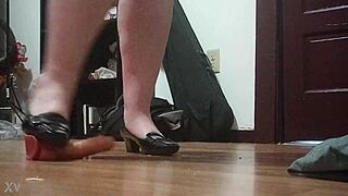 Woman crushes cock under sharp heels in intense foot fetish session.