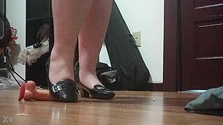 Woman crushes cock under sharp heels in intense foot fetish session.