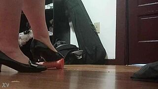 Woman crushes cock under sharp heels in intense foot fetish session.