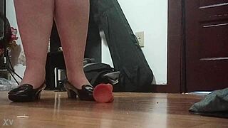 Woman crushes cock under sharp heels in intense foot fetish session.