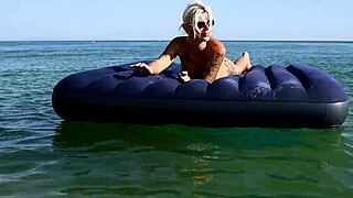 Who's that big-titted blonde flashing her pussy on the nude beach?