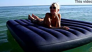 Who's that big-titted blonde flashing her pussy on the nude beach?