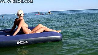 Who's that big-titted blonde flashing her pussy on the nude beach?